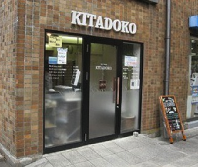 Before — original KITADOKO storefront, brick facade with cluttered signage