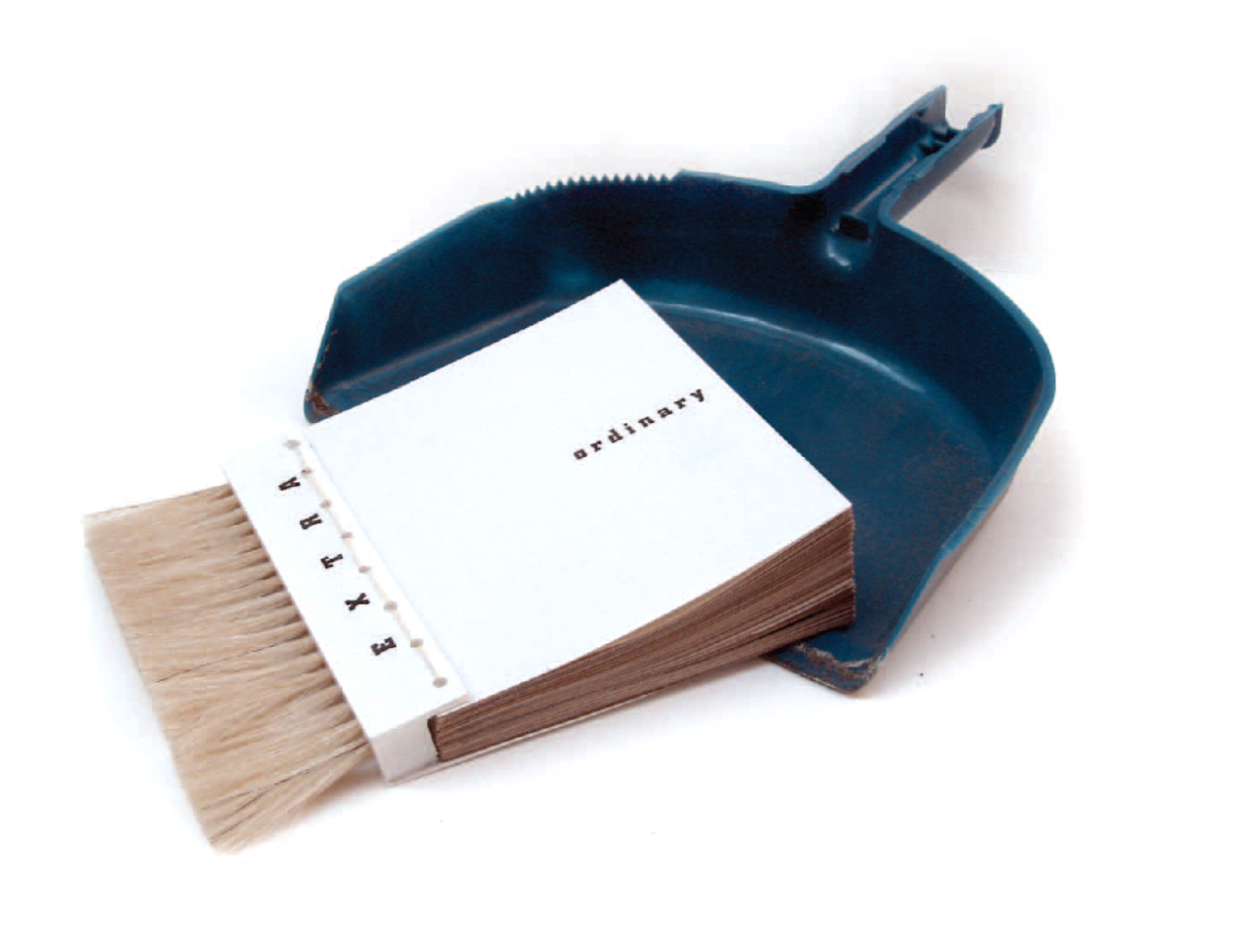 The first handmade prototype — the book's spine is a real brush, resting in a dustpan