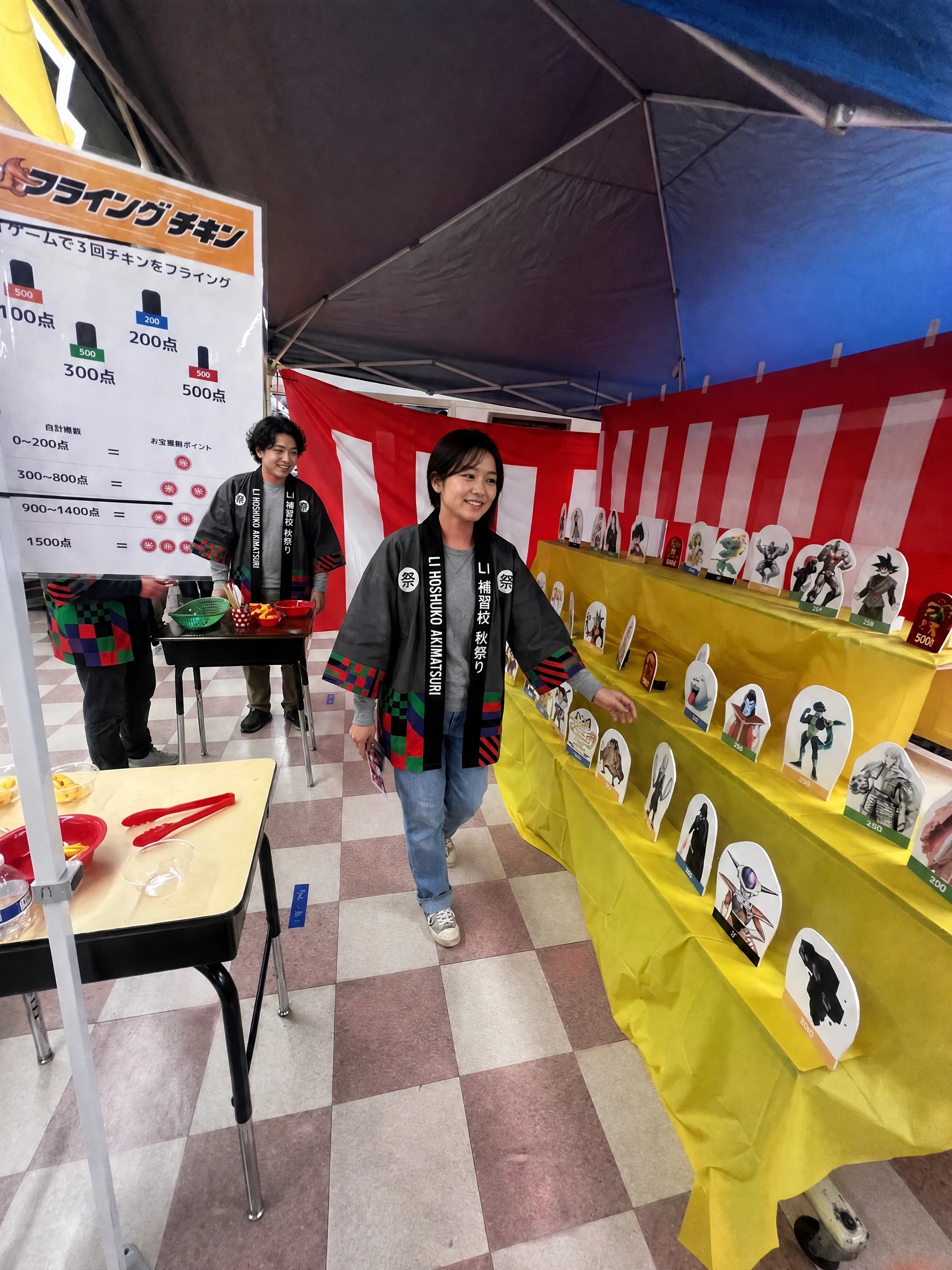 Rows of cut-out targets on a yellow shelf inside the Flying Chicken tent, with the points board on the left